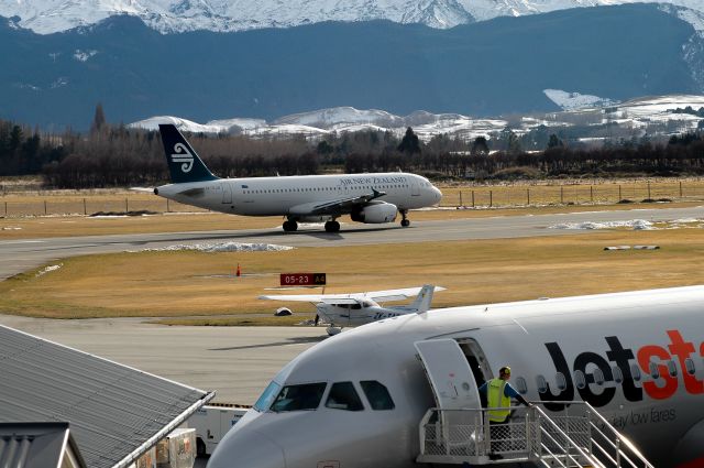 Airbus A320 (ZK-OJO) - 24 August 2011. Taken from the roof of the Queenstown International Airport roof, OJO backtracking on the runway for a departure out of paradise, probably with a load of tired skiers!