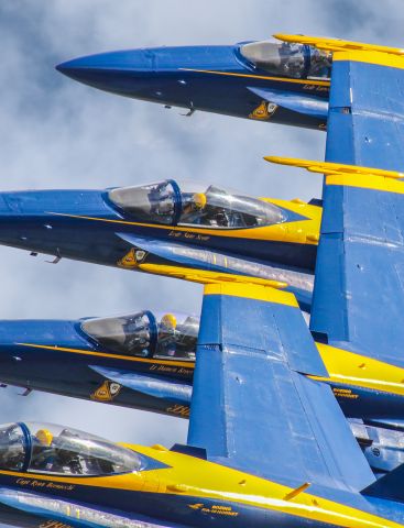 McDonnell Douglas FA-18 Hornet — - I love it when I get shots like this where you can see the Blue Angels pilots concentrating on the aircraft to their left when flying in these tight formations. Being able to see their yellow tinted visors and microphones in the photo as they were flying over at a couple hundred miles per hour is really cool. I shot this at the Wings over North Georgia airshow. I used my 600mm Canon lens with shutter at 1/8000, F6.3, ISO 1000. Please check out my other aviation photography. Votes and positive comments are always appreciated. Questions about this photo can be sent to Info@FlewShots.com