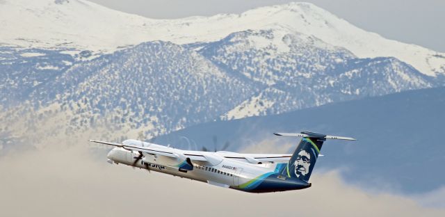 de Havilland Dash 8-400 (N446QX) - Emerging from a thick blanket of ground-level fog in the Truckee Meadows between two mountain ranges (the Virginia Range in the east and the Sierra Nevada in the west), QXEs N446QX is momentarily clearly visible as it climbs out from 16R and toward the gray skies over Mt. Rose and Slide Mountain southwest of Reno.