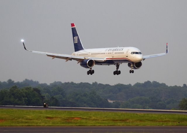 Boeing 757-200 (N939UW) - Landing at dusk on runway 23, Charlotte, North Carolina USA. The anti-collision strobe light has just flashed on the right wing.