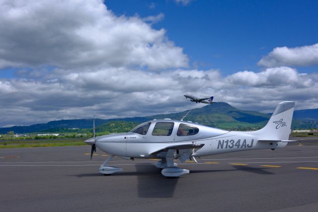 Cirrus SR-22 (N134AJ) - N134AJ standing on the ramp as a United regional jet is taking off