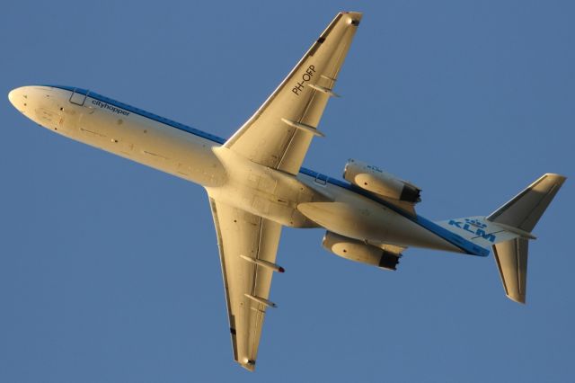 — — - Belly shot of the Fokker F28 at sunset.