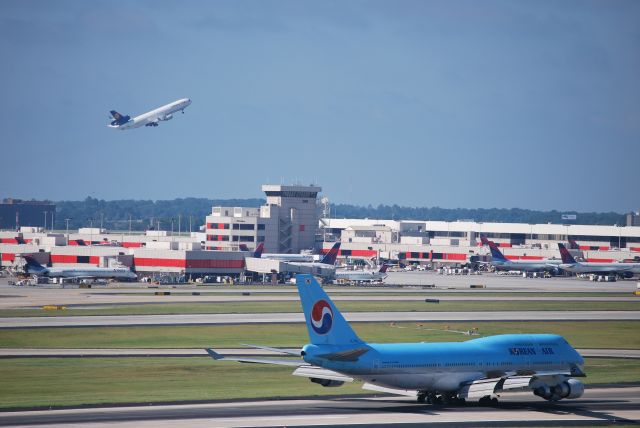 Boeing 747-400 (HL7460) - Arriving runway 26R, while Lufthansa Cargo MD11 departs runway 27R in the background - 8/23/09