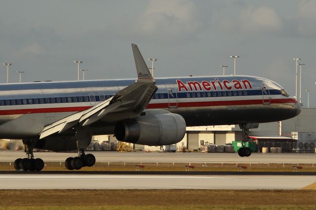 Boeing 757-200 (N645AA) - American flight 2144 from Princess Juliana Intl (St. Maarten) reluctantly settling down RWY 9, with crosswinds, at pre-sunset. Taken from just east of El Dorado Furniture. 3/31/13