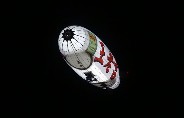 B-9003 — - An airship carry the advertisement of Wanglaoji Herbal Tea flying in evening of Guangzhou, China.