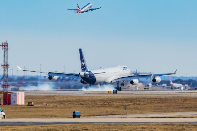 Airbus A340-300 (D-AIGU) - Lufthansa A340-300 landing at DFW while an American Eagle Embraer 175 departs on 12/25/22. Taken with a Canon R7 and Tamron 70-200 G2 lens.