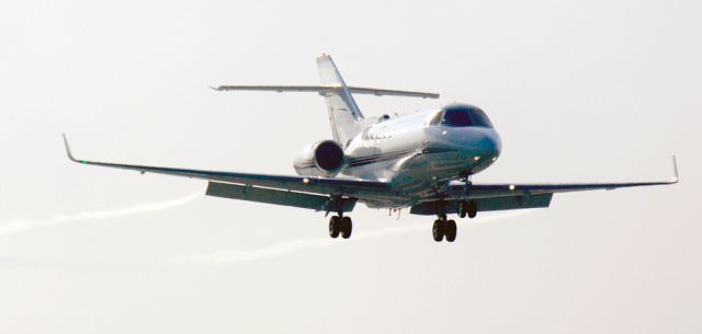 Cessna Citation Sovereign (N877QS) - NetJets Hawker breaks out of the fog trailing vortices from its flaps