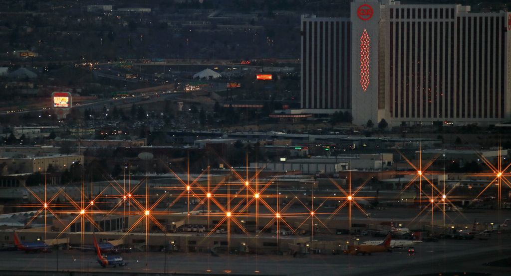 — — - Nine of the 18 passenger aircraft that normally RON at Reno Tahoe International were still at or near the terminal when the first dawn light of a new day provided enough illumination for me to take this long-range shot of the airport terminal area from the top of Rattlesnake Mountain which is well over a mile away.  Southwests New Mexico One is visible at one of the "B Concourse" gates and another Southwest 737 has already been pushed back.