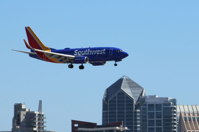 Boeing 737-700 (N778SW) - Southwest landing with new livery. San Diego skyline visible in the background. 