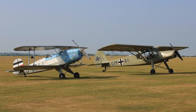 — — - Bucker Jungman G-BSAJ and a Fieseler Storch at Duxford Flying Legends air show.