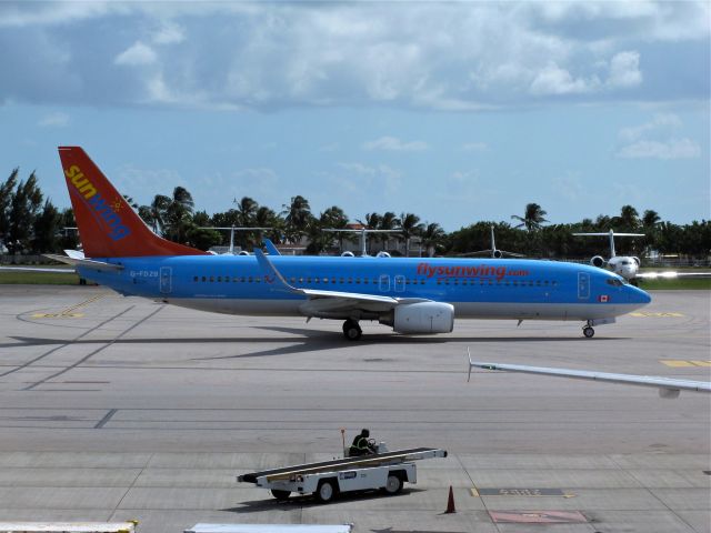 Boeing 737-700 (G-FDZB) - Taxiing in at Princess Juliana, Sint Maarten before departing for Montreal (YUL) with a fuel stop in Punta Cana, Dominican Republic. Interestingly, a British registration and an aircraft leased from the German TUI holiday group.  Interior signs are all in English and German..