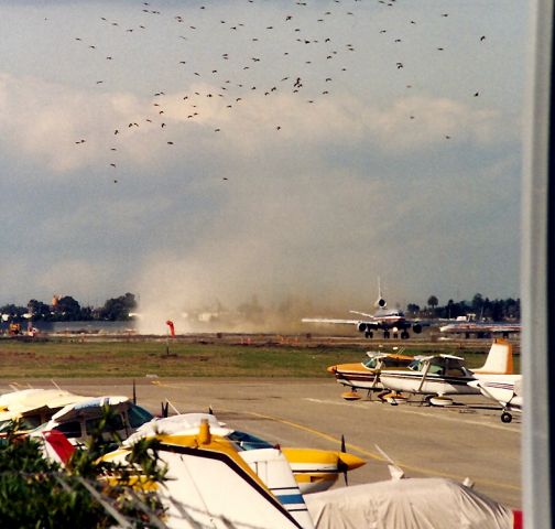 McDonnell Douglas DC-10 — - KSJC - American DC 10 departing 12 R in this poss 1990 view, of SJC only main runway having some work done before the MD 11 s arrived in 1991 - this HNL bound passenger jet kicked up quite the dust storm, not to mention a few black birds.