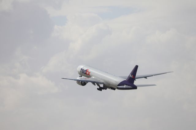 BOEING 777-200LR (N893FD) - FedEx 777 "Anastasija" departing into a partly cloudy sky.