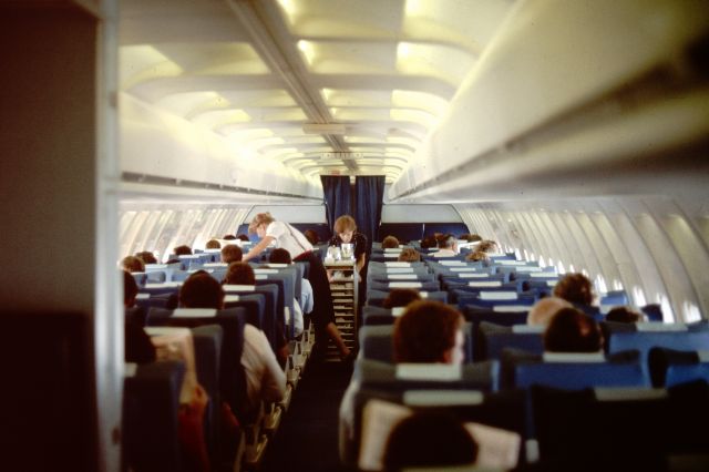 BOEING 727-200 (UNKNOWN) - Enroute Melbourne to Sydney March 1983 with TAA (since merged into Qantas).  Crew serving meals and drinks which were included as part of the price.  Curtain separates business class passengers up front from economy at rear. Aircraft details not recorded.