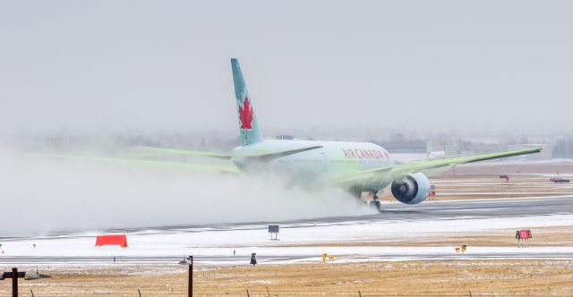 Boeing 777-200 (C-FIVK) - ACA15 kicks up some snow as she departs to Hong Kong on runway 23