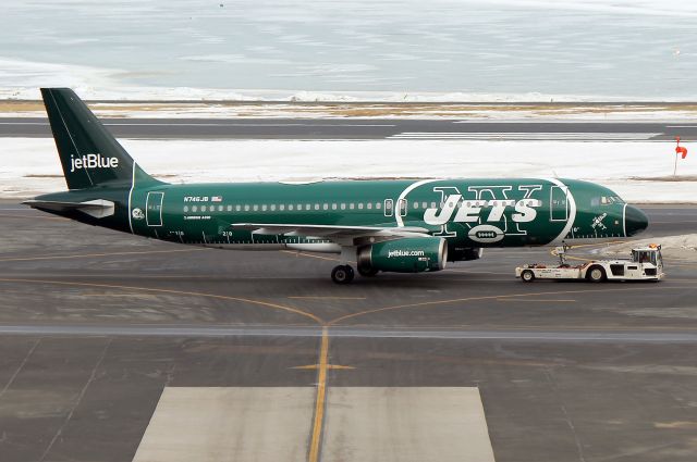 Airbus A320 (N746JB) - JetBlues NY Jets logo jet being tugged from N. Cargo where it spent the night after its late evening arrival from Aruba