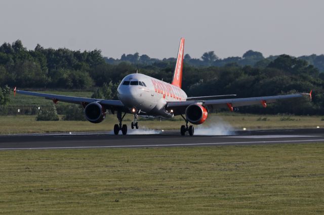 Airbus A319 (G-EZDF) - EZY1896 touches down in the evening light after the flight from Berlin SXF