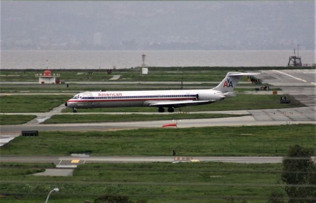 McDonnell Douglas MD-83 (N562AA) - KSFO - High winds and rain in April 2005 has all aircraft using Runways 19LR approach over San Francisco bay in a westerly direction after arriving over the Oakland CA area shown in the back ground. This ship is LN 1370 and shown on taxi after landing 19L, and headed towards and to across 19R and to the Terminal