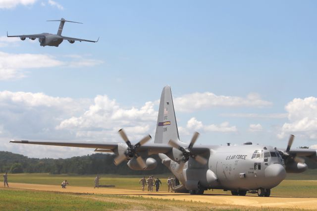 Lockheed C-130 Hercules (92-3288) - A USAF C-17 Globemaster III, 97-0048, cn P-48, from the 445th Airlift Wing, Wright-Patterson AFB, OH, departing Young Air Assault Strip behind a USAF Lockheed C-130H, cn 382-5353, from the 934th Airlift Wing, Flying Vikings, Minneapolis, MN on 26 Jul 2013.