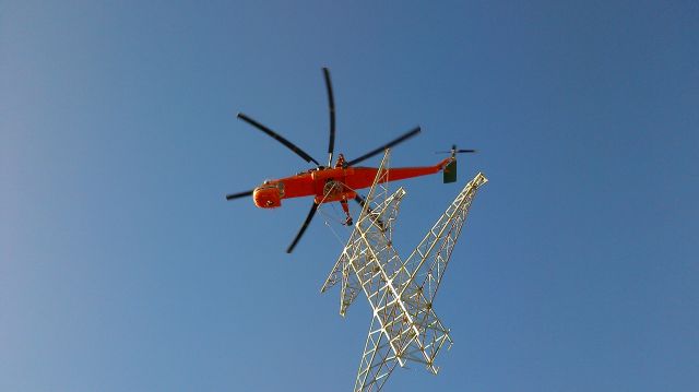 — — - Erickson sky crane right over top, moving powerline structures