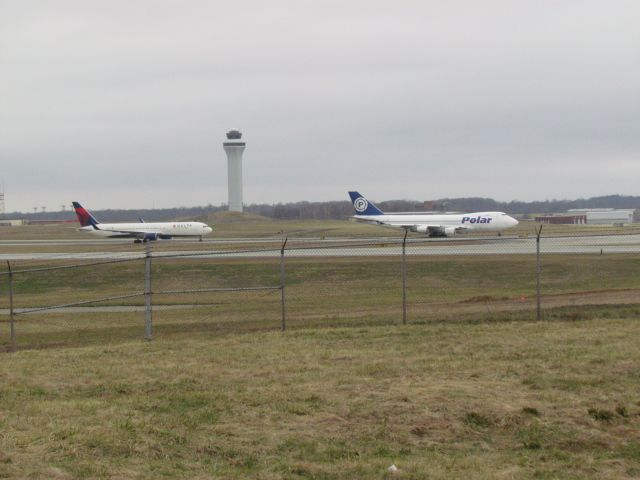 BOEING 767-300 (N152DL) - Front aircraft is Polar Air Cargo 747-400 (N450PA)br /Rear Aircraft is Delta 767-300 (N152DL)br /br /The Delta had just landed on 18L and the Polar is taxiing to takeoff on runway 27