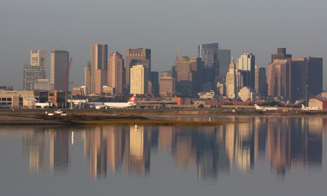 BOEING 777-300ER (HB-JNJ) - Swiss B777-300 at Logan's Terminal E while the city of Boston's reflection in the water in the early morning on 9/25/20.