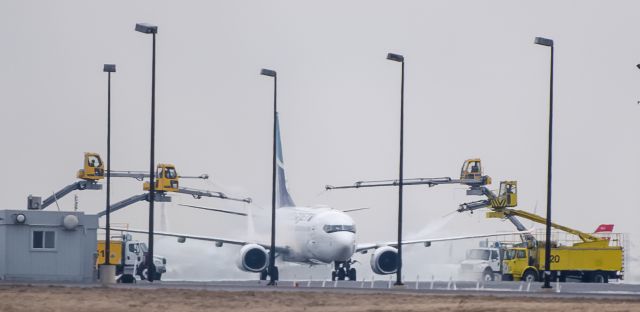 Boeing 737-700 — - WestJet full service snow bathing by 4 service truck 2015-April-05